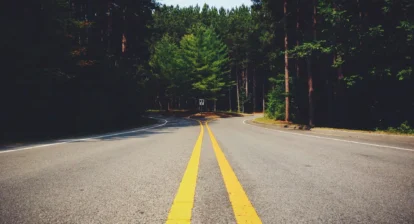 A Road with two yellow lines going throught the middle