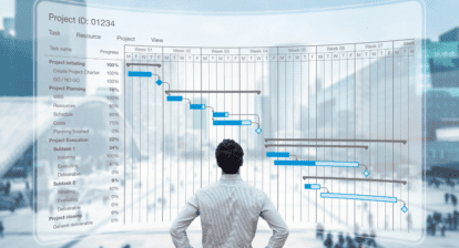The image shows a project manager looking at a project schedule. The schedule shows the tasks that need to be completed, the resources that are required, and the timeline for the project. The project manager is using the schedule to track the progress of the project and to identify any potential problems.